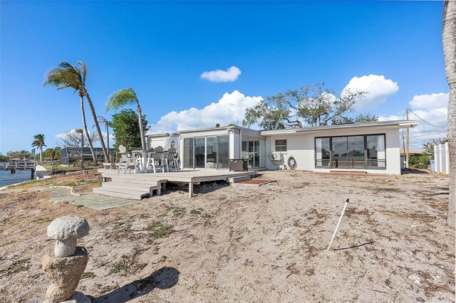 back of property featuring a wooden deck and a sunroom