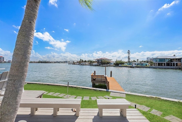 view of dock with a lawn and a water view