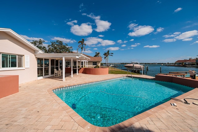 view of pool featuring a water view, a dock, and a patio