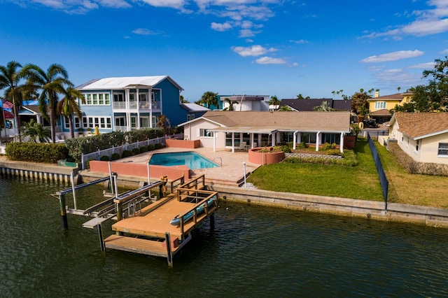 rear view of property featuring a patio area, a water view, a yard, and a jacuzzi