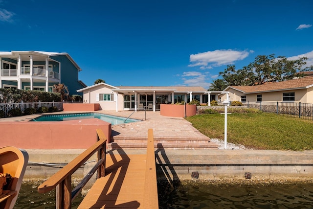 exterior space with a yard, a water view, a fenced in pool, and a patio area