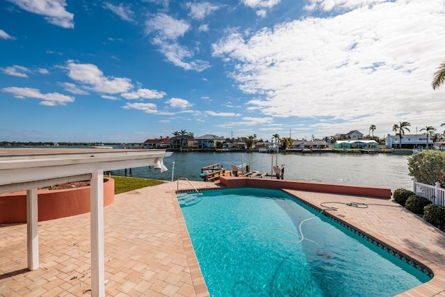 view of swimming pool featuring a water view and a patio area