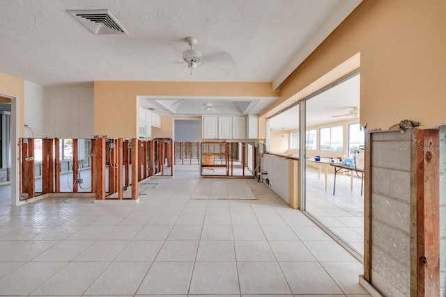 hall featuring light tile patterned flooring and a textured ceiling