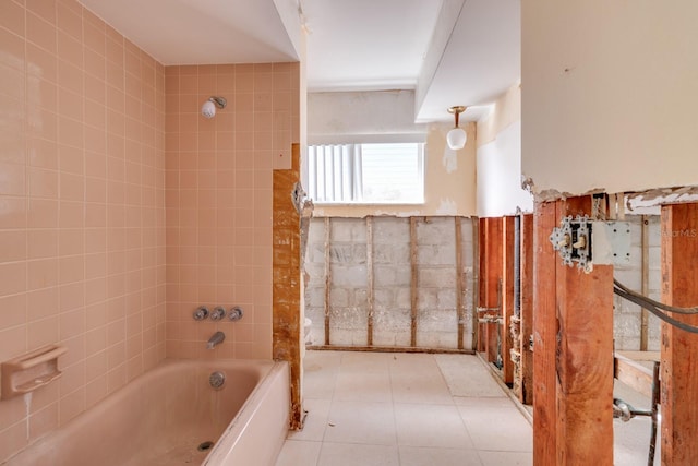 bathroom with tile patterned flooring, tiled shower / bath combo, and tile walls