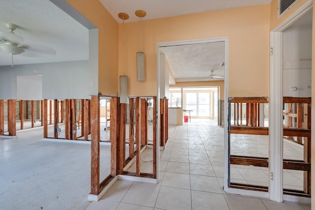 hallway with light carpet and a textured ceiling