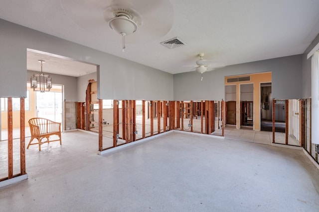 spare room with ceiling fan with notable chandelier