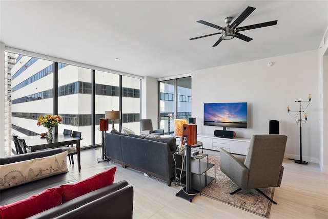 living room featuring ceiling fan, light hardwood / wood-style flooring, expansive windows, and a healthy amount of sunlight