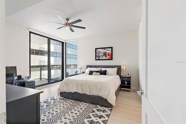 bedroom with floor to ceiling windows, access to exterior, ceiling fan, and light hardwood / wood-style floors