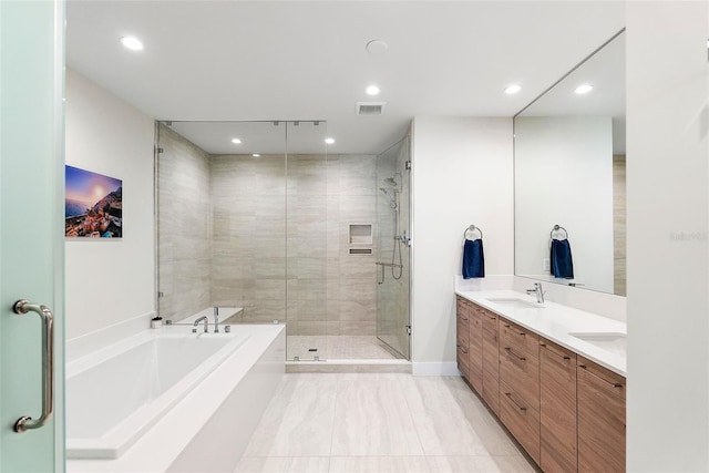 bathroom featuring vanity and independent shower and bath