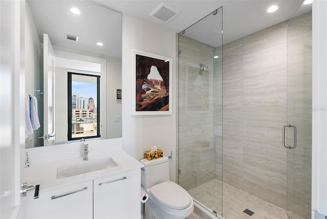 bathroom featuring vanity, toilet, and a shower with shower door