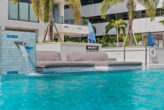 view of swimming pool with pool water feature