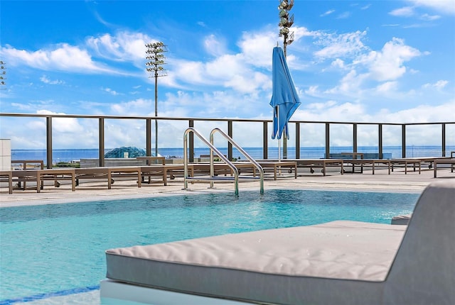 view of swimming pool featuring a water view