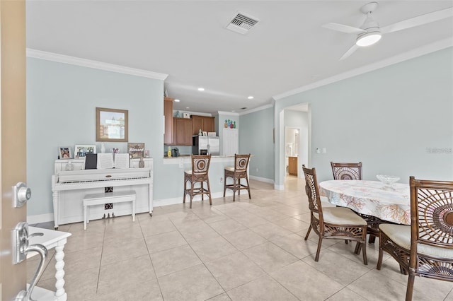 tiled dining area featuring ceiling fan and ornamental molding