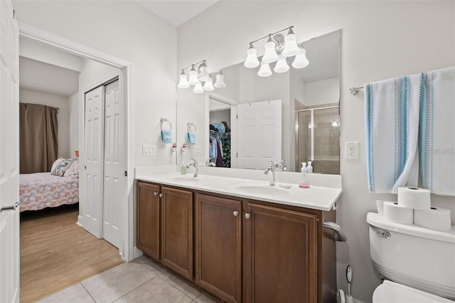 bathroom featuring vanity, wood-type flooring, an enclosed shower, and toilet