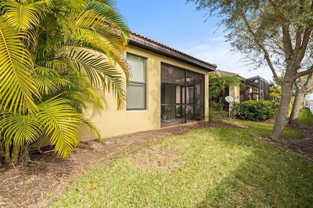 exterior space featuring a yard and a sunroom