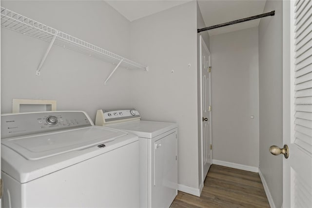 clothes washing area featuring dark hardwood / wood-style flooring and washer and clothes dryer