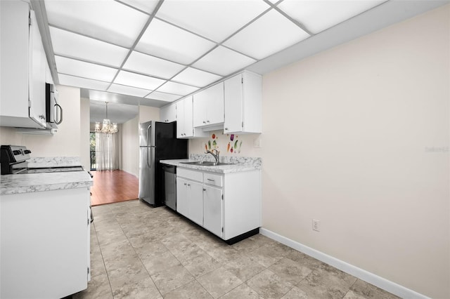 kitchen with white cabinetry, sink, a chandelier, decorative light fixtures, and appliances with stainless steel finishes