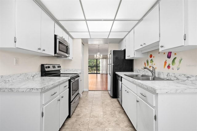 kitchen with sink, white cabinetry, stainless steel appliances, and a chandelier