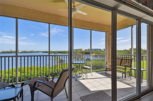 unfurnished sunroom with a water view and ceiling fan