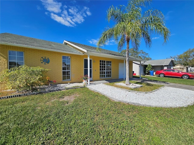 3141 Ludlow Dr, New Port Richey, FL 34655 - single story home with brick siding, a front lawn, a garage, and a porch
