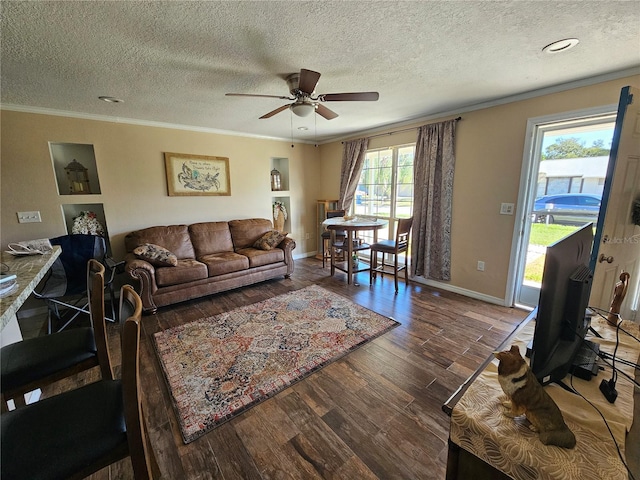 living room with a textured ceiling, dark hardwood / wood-style flooring, ceiling fan, and ornamental molding