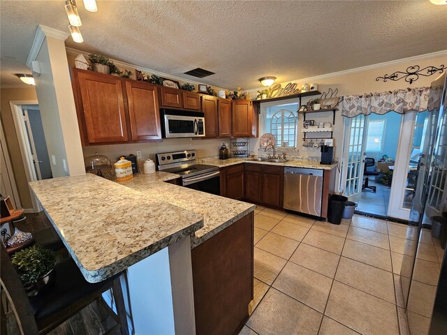 3141 Ludlow Dr, New Port Richey, FL 34655 - kitchen featuring appliances with stainless steel finishes, ornamental molding, a sink, a peninsula, and a textured ceiling