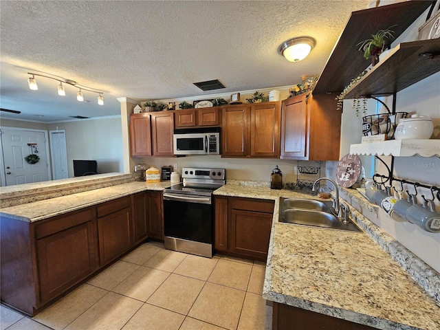 kitchen featuring sink, light tile patterned floors, a textured ceiling, kitchen peninsula, and stainless steel appliances