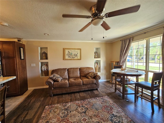 living room featuring hardwood / wood-style floors, ceiling fan, crown molding, and a textured ceiling