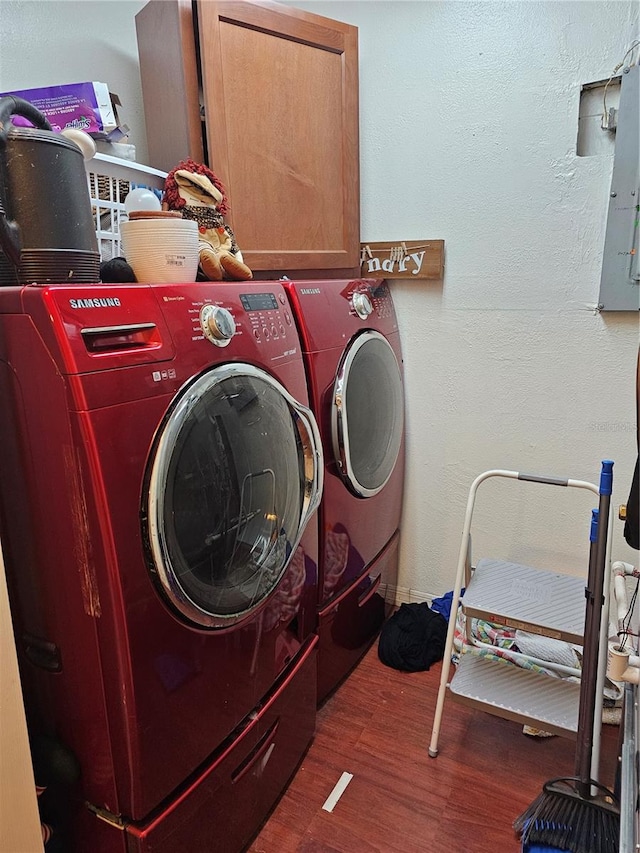 laundry area featuring washing machine and dryer, cabinets, and dark hardwood / wood-style floors