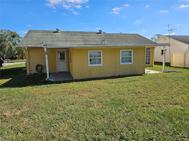 rear view of property with a yard