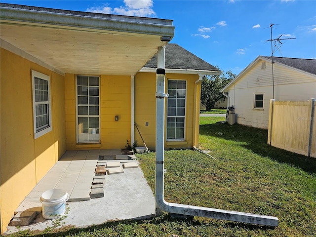 view of exterior entry featuring a yard and a patio