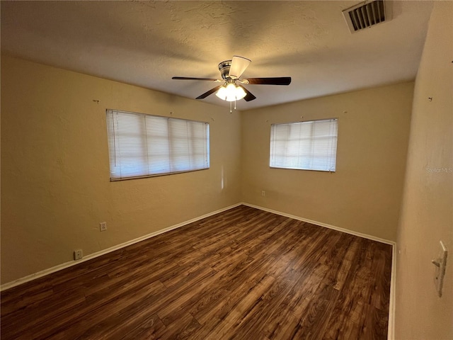 spare room with a textured ceiling, dark hardwood / wood-style floors, and ceiling fan