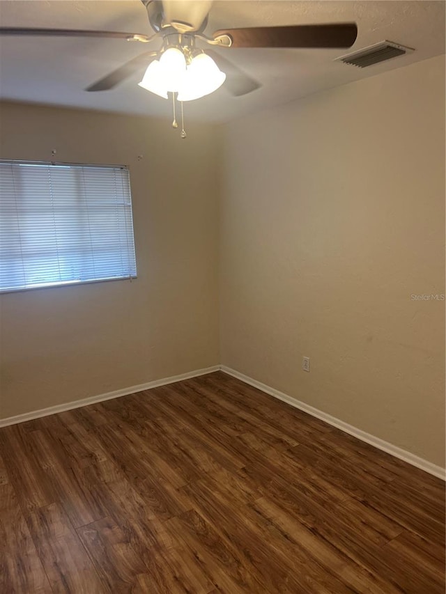 empty room with dark hardwood / wood-style flooring and ceiling fan