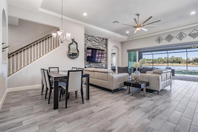 living room with ceiling fan with notable chandelier, light hardwood / wood-style flooring, and crown molding