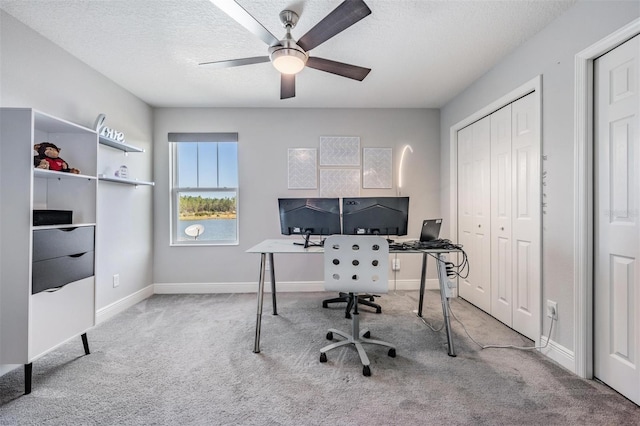 carpeted home office featuring ceiling fan and a textured ceiling