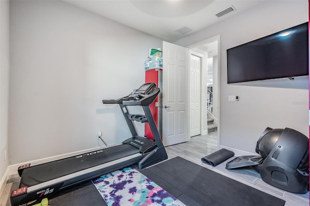 exercise room with light hardwood / wood-style flooring