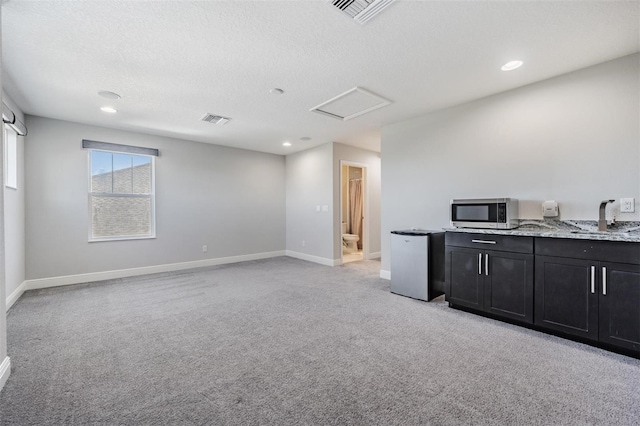 living room with sink, light colored carpet, and a textured ceiling