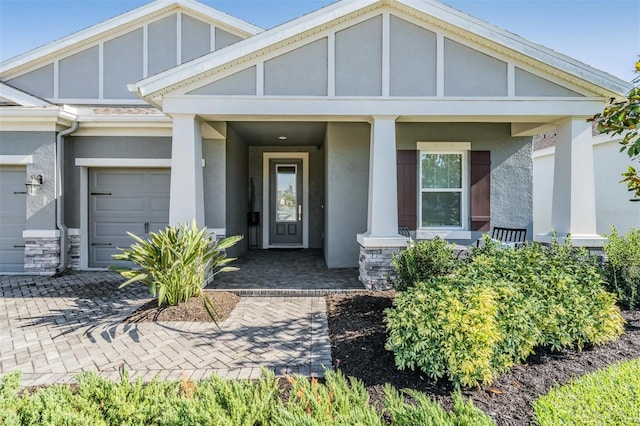 doorway to property featuring covered porch and a garage