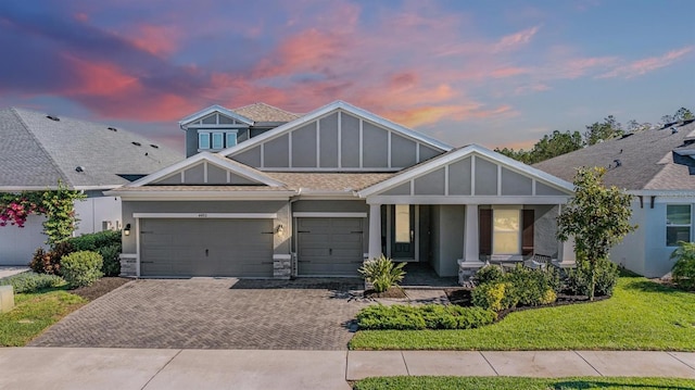 view of front of home with a garage and a lawn