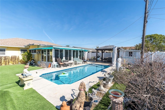 view of swimming pool featuring a yard, a gazebo, a patio area, and a sunroom