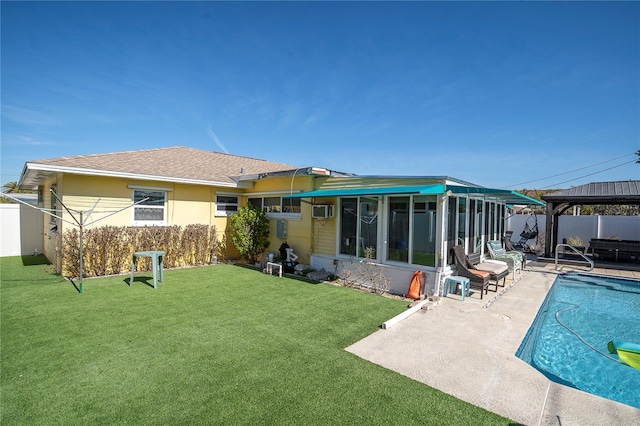 back of house with a fenced in pool, a lawn, a gazebo, a patio, and a sunroom