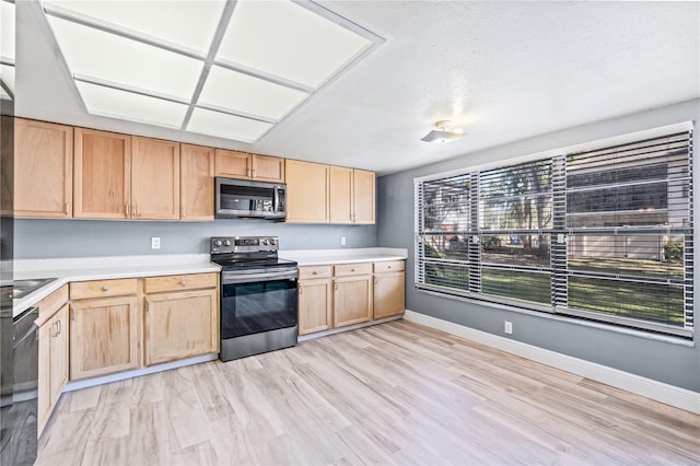 kitchen featuring a textured ceiling, light wood-type flooring, light brown cabinetry, and appliances with stainless steel finishes