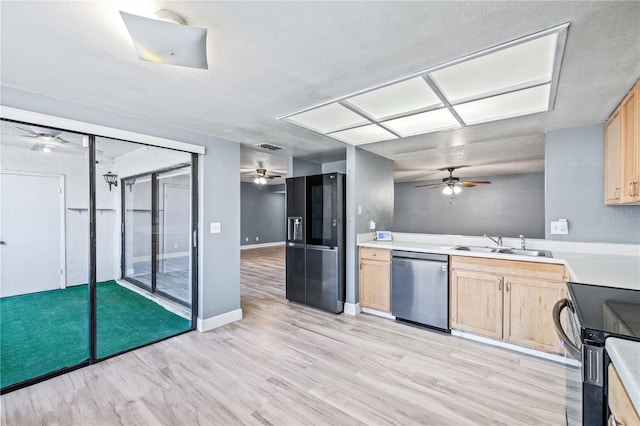 kitchen with sink, light brown cabinetry, black appliances, and light hardwood / wood-style floors