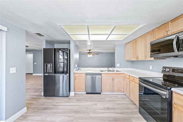 kitchen featuring visible vents, appliances with stainless steel finishes, light brown cabinetry, light wood-type flooring, and a sink