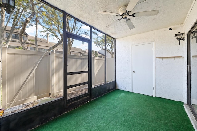 unfurnished sunroom with ceiling fan