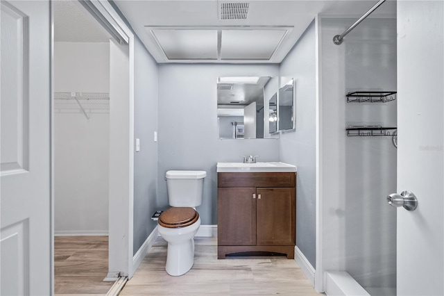 bathroom with hardwood / wood-style floors, vanity, and toilet