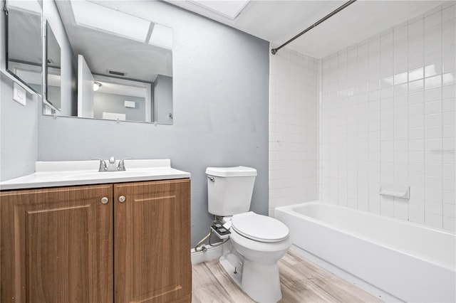 full bathroom featuring baseboards, toilet, wood finished floors,  shower combination, and vanity