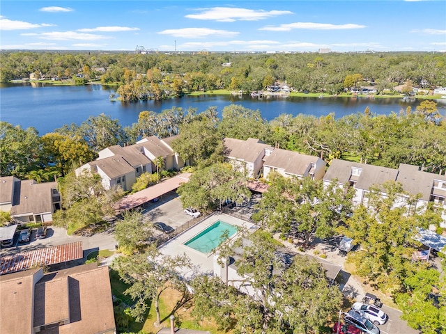 birds eye view of property with a water view and a wooded view