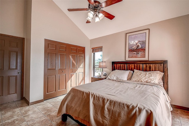 tiled bedroom with ceiling fan, a closet, and high vaulted ceiling