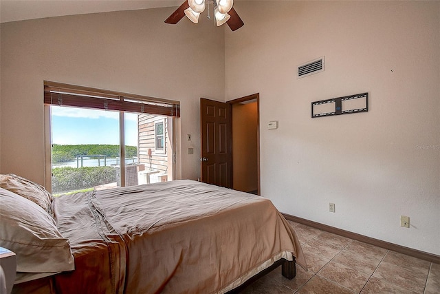 bedroom featuring ceiling fan, a water view, light tile patterned flooring, and high vaulted ceiling